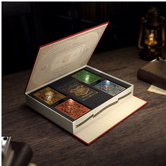 Open geschenkdoos met vijf verschillende Harry Potter speelkaarten, in kleuren rood, goud, zilver, groen en blauw.