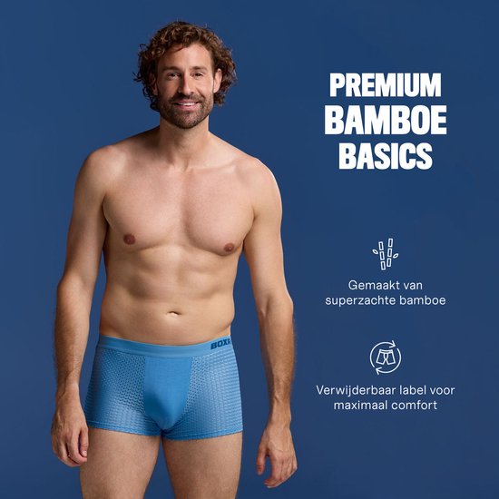 Man in blauwe BOXR boxershort, gemaakt van bamboe. Tekst "PREMIUM BAMBOE BASICS", "Gemaakt van superzachte bamboe" en "Verwijderbaar label".