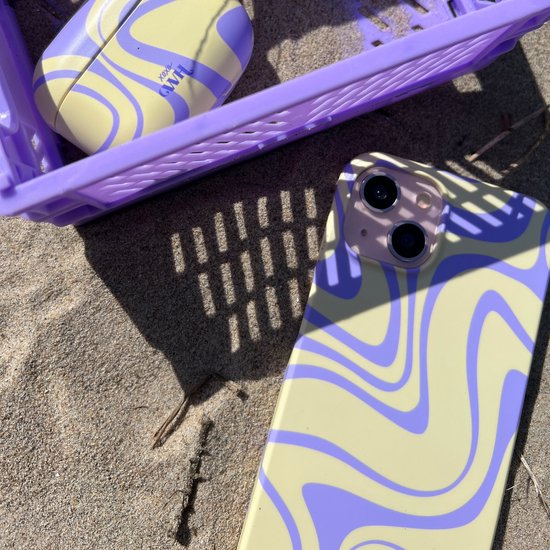 iPhone hoesje en AirPods hoesje met geel en paars golvend patroon, op zand.