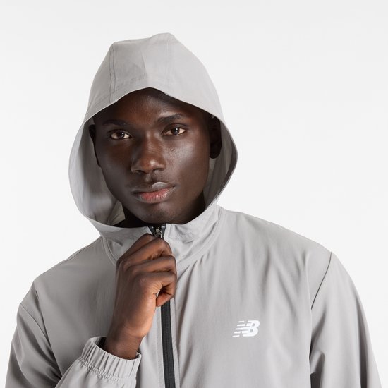 Close-up van een man met grijze New Balance sportjas met capuchon.