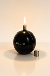 Zwarte, bolvormige olielamp van Afecto met Afecto logo. Met brandende lont en metalen dop aan ketting.