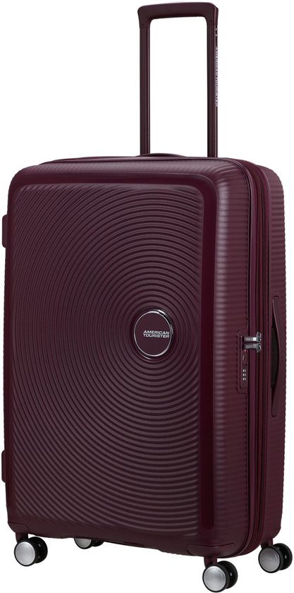 Burgondische koffer met cirkelvormig patroon en 'American Tourister' logo. Uitschuifbaar handvat en vier wielen.
