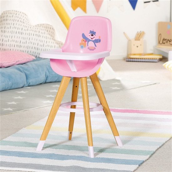 Roze poppenkinderstoel met houten poten en een beer met gele boodschappentas op de rugleuning.