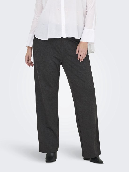Model in donkergrijze wijde broek met witte blouse, van voren gezien.