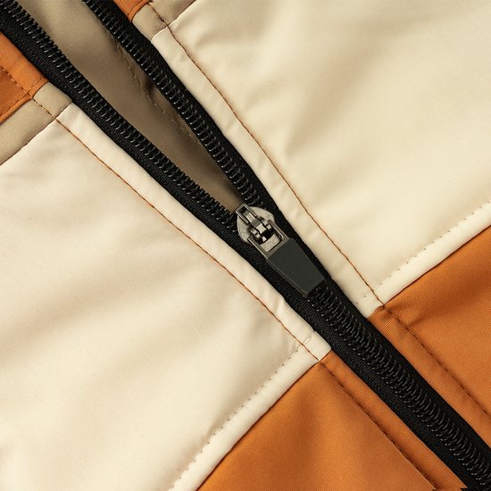 Close-up van een zwarte rits op een oranje-beige jas voor honden.