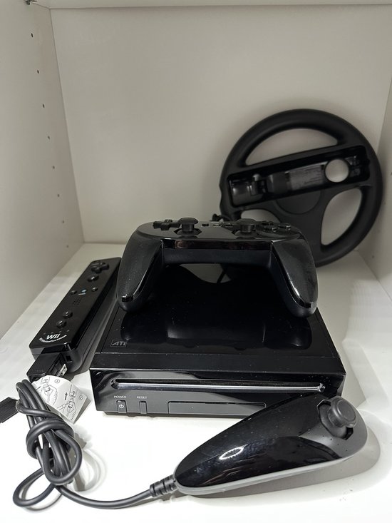 Zwarte Nintendo Wii console met controller, Nunchuk, stuur en Wii-afstandsbediening.