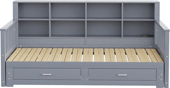 Grijze slaapbank met open opbergvakken boven en twee lades.