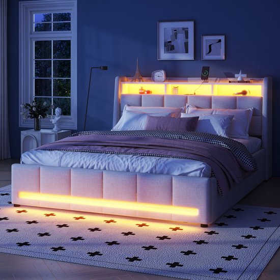 Wit gestoffeerd bed met LED-verlichting in het hoofdbord en langs de onderkant, de verlichting is geel.