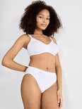 Model met een witte, beugelloze bh en bijpassende slip. Ze draagt het haar los.