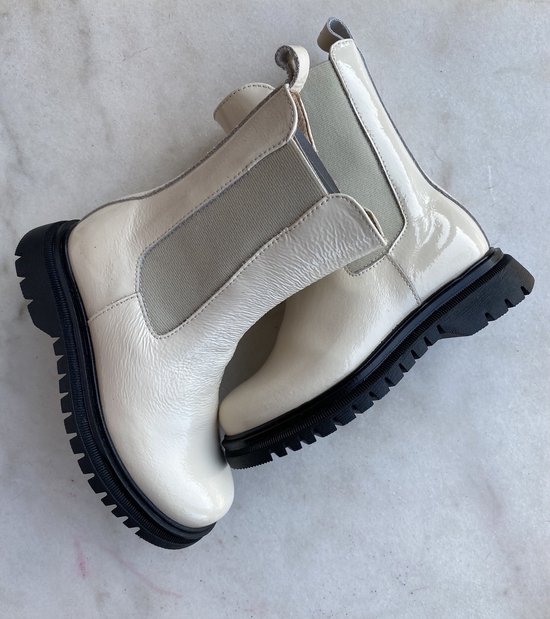 Glanzende witte lakleren chelsea boots met zwarte profielzolen en beige elastische zijpanelen.