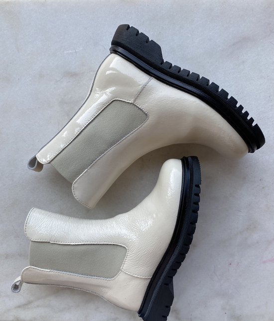 Glanzende witte lakleren chelsea boots met zwarte profielzolen en beige elastische zijpanelen.