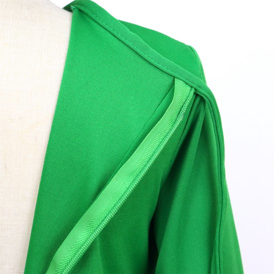 Schouderdetail van een groen kostuum met een zichtbare ritssluiting.