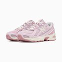 Lichtroze New Balance sneakers met beige en roze details, witte N-logo's en witte veters.