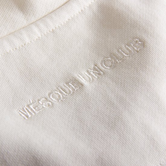 Ecru sweater met geborduurde tekst 'MÉSOUL UNICLUB' in reliëf.