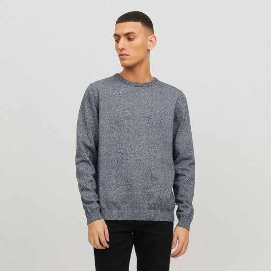 Man met een donkerblauwe gebreide trui met ronde hals en zwarte jeans.