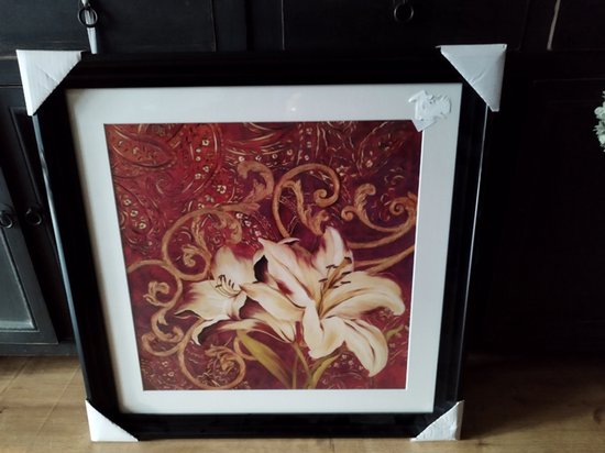 Schilderij met witte lelies en rood paisley patroon, zwart omlijst.