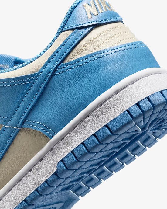 Close-up van de hiel en zool van een Nike Dunk Low sneaker, met lichtblauwe en crème details.