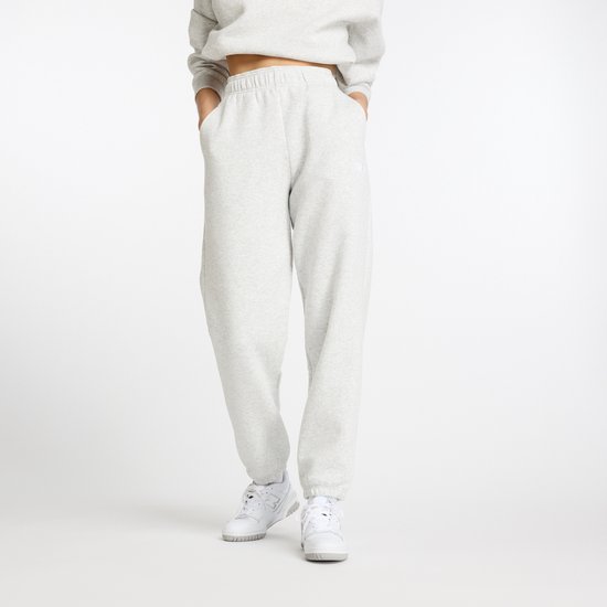 Model in een lichtgrijze joggingbroek en grijze crop top.