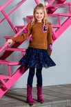 Meisje in een glitter top, donkerblauwe pailletten rok en roze laarzen.