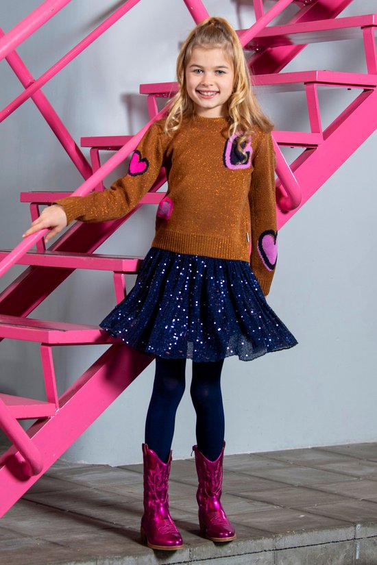 Meisje in een glitter top, donkerblauwe pailletten rok en roze laarzen.