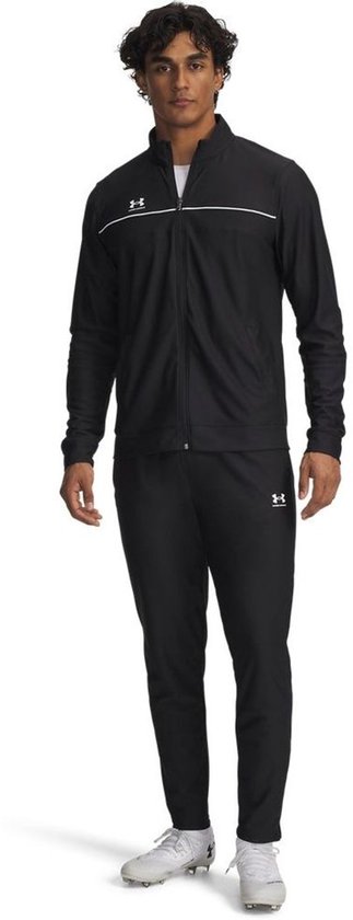 Man in zwart Under Armour trainingspak met witte streep op de jas.