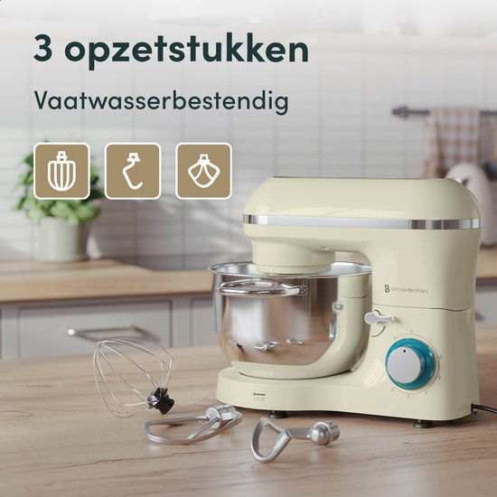 Crème keukenmachine met RVS mengkom en drie opzetstukken op een houten aanrecht.
