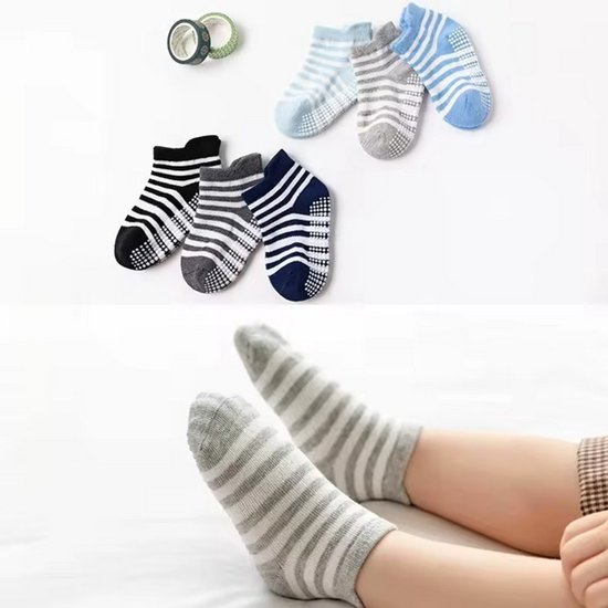 Een kind draagt grijze gestreepte enkelsokken met antislip nopjes. Op de achtergrond liggen drie paren sokken in zwart, grijs en blauw, en twee paren in lichtblauw en grijs.