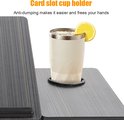 Detail van een donkergrijs houten laptoptafel met een sleuf voor een bekerhouder en een glas met citroen.