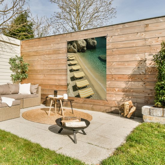 Tuinposter 90x120 cm - Tuindecoratie Strandbedden - Zee - Stenen - Baai - Poster voor in de tuin - Buiten decoratie - Schutting tuinschilderij - Tuindoek muurdecoratie - Wanddecoratie balkondoek