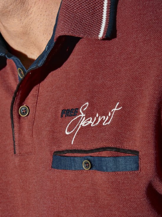 Detail van rood langarm polo shirt met 'Free Spirit' borduring en denim zakje.