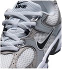 Close-up van witte en zilverkleurige Nike sneaker met zwarte swoosh en veters.