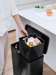 Een hand pakt een zwarte binnenemmer uit de Curver Deco Bin.