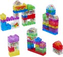 Transparante, gekleurde bouwblokken gevuld met kleine, kleurrijke balletjes. Verschillende constructies op de foto.