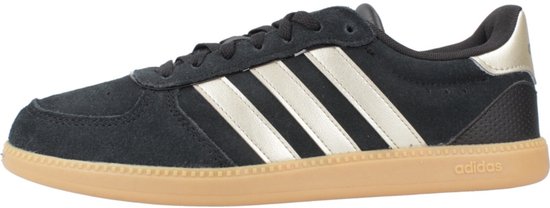 Zwarte Adidas sneaker met gouden strepen en gummi zool, zijaanzicht.