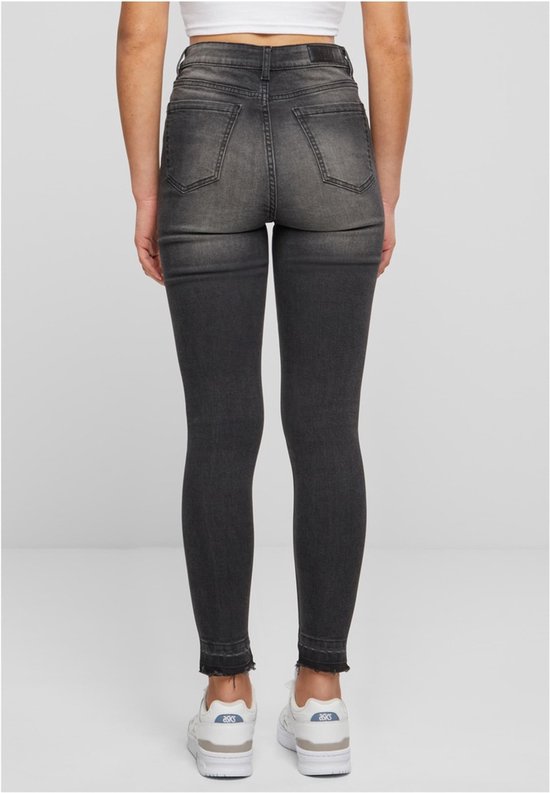 Dames skinny jeans in zwart gewassen denim met rafelige zoom. Zichtbaar vanaf de achterkant.