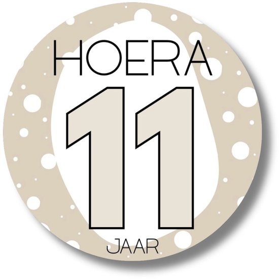 Ronde sticker met 'HOERA 11 JAAR' op een beige achtergrond met witte stippen.