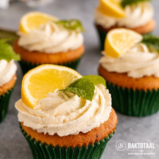 Citroen cupcakes met crème, citroenschijfje en muntblaadje in een groene cupcakevorm.
