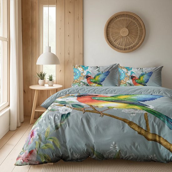 Een tweepersoonsbed met dekbedovertrek en kussens, versierd met vogels, bloemen en mandala's in een slaapkamer.