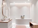 Lichte badkamer met witte tegels, ovaal bad, ronde wastafel en gouden kraan.
