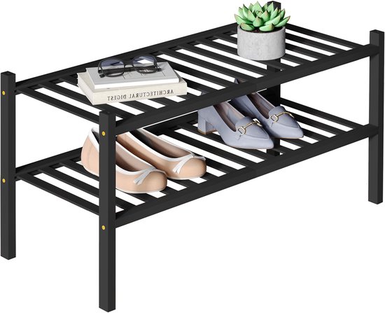 Étagère à chaussures noire à 2 niveaux avec des chaussures plates, des mocassins et une plante et un livre.