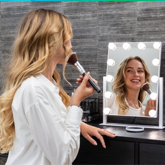 Vrouw met blonde haren gebruikt make-up met een Mirlux Hollywood spiegel met verlichting.