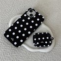 Zwart telefoonhoesje met witte stippen en een bijpassend zwart oplaaddoosje voor oordopjes met stippen.