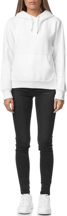 Model van voren in een witte hoodie met capuchon en zwarte skinny jeans.