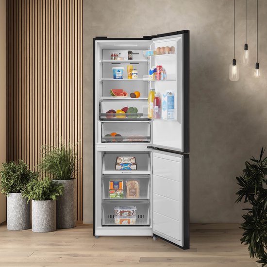 Zwarte Inventum koel-vriescombinatie met open deuren, gevuld met diverse etenswaren zoals fruit, groenten en zuivel.