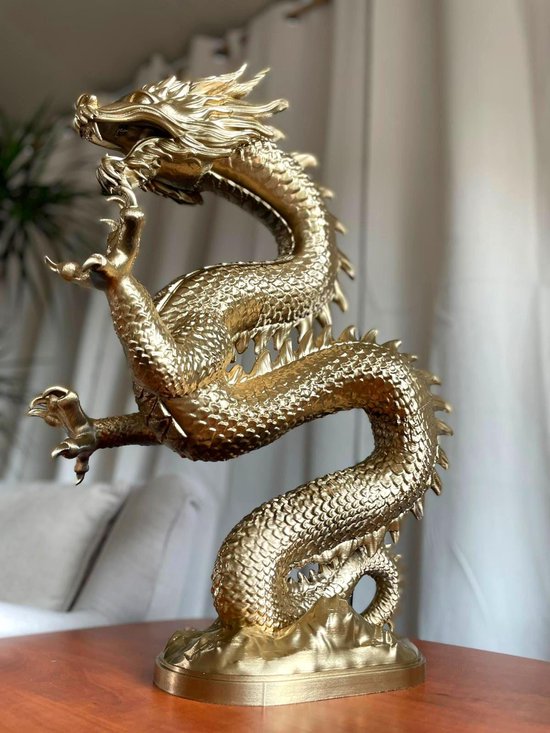 Gouden draak ornament op een tafel, met zachte meubels op de achtergrond.