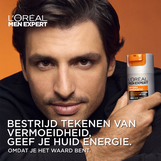 Middelbare schouder shot van een man die een L'Oréal Men Expert Hydra Energetic crème vasthoudt.