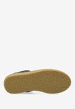 Crèpe zool van een donkerbruine suède sneaker.