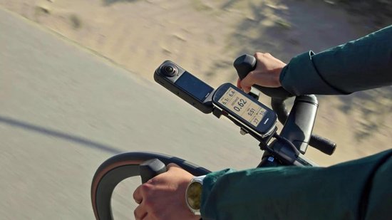 Persoon fietst, actioncam en fietscomputer gemonteerd op stuur.