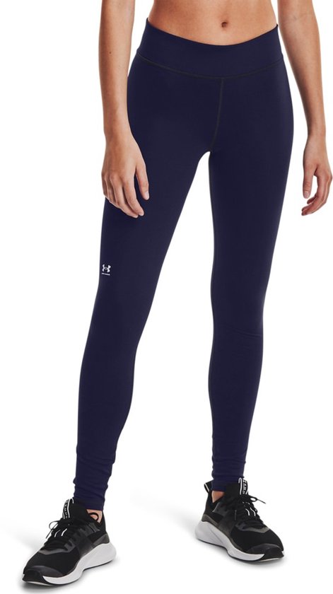 Model in donkerblauwe Under Armour legging met logo op linkerbeen, gedragen met zwarte sportschoenen.