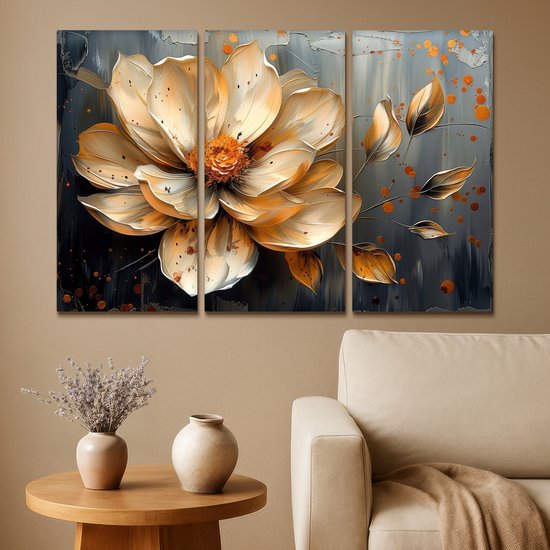 Une peinture triptyque d'une fleur abstraite dorée avec des accents orange sur un fond gris foncé, à côté d'un canapé.